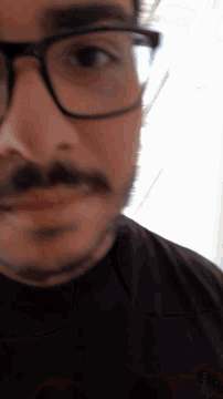 a close up of a person wearing glasses with their eyes closed