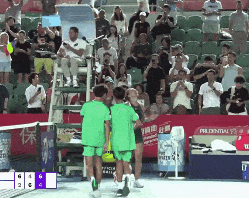 a tennis match is being played in front of a crowd and a sign that says prudential on it