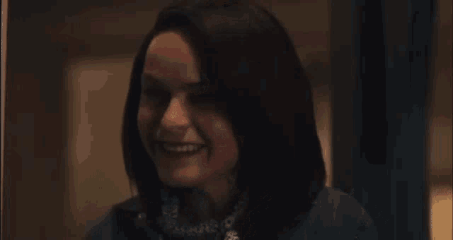 a close up of a woman smiling in a dark room .