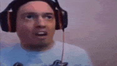 a man wearing headphones and a white shirt is making a surprised face .