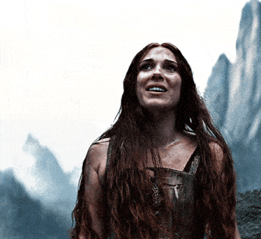 a woman with long red hair is looking up at something