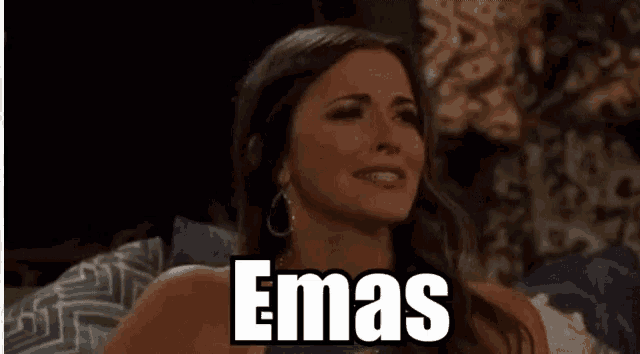 a woman is sitting on a couch with a sign that says emas on her face .