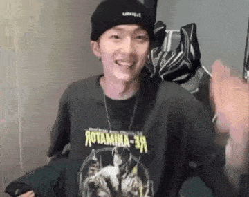 a young man wearing a beanie and a t-shirt is smiling .