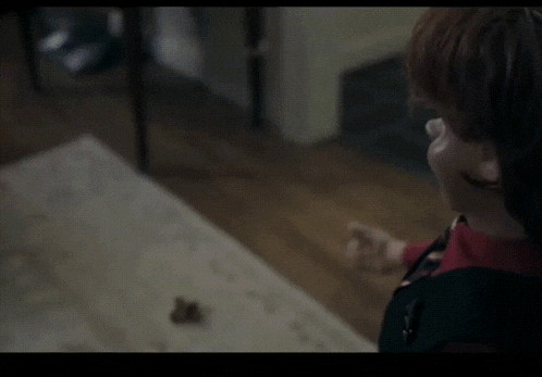 a puppet wearing a red shirt and black vest and tie