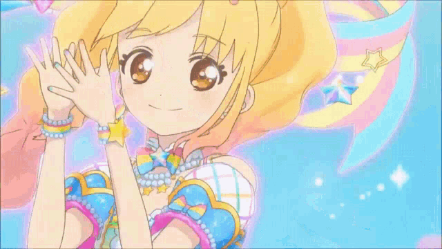 a girl in a blue dress with a rainbow on her head is standing on a stage .