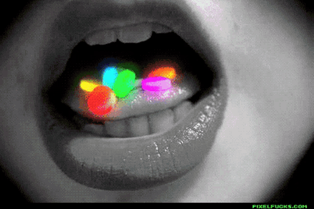a black and white photo of a woman 's mouth with glow in the dark pills in it
