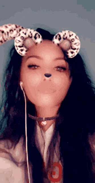 a woman is wearing a snapchat filter with a leopard print on her ears .