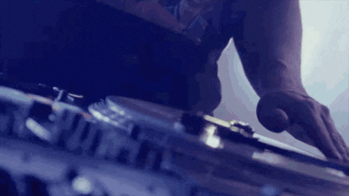 a close up of a dj 's hands playing music on a turntable .
