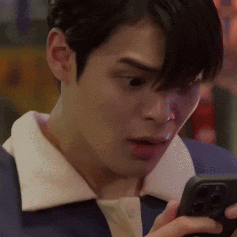 a close up of a man looking at his cell phone .