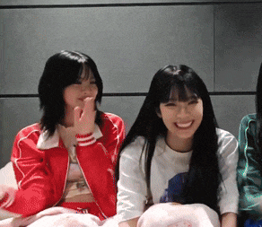 a woman in a red jacket sits next to another woman