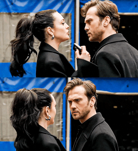a man and a woman are looking at each other in front of a blue tent