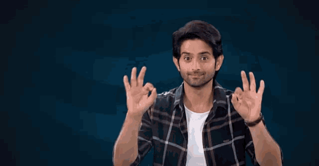 a man in a plaid shirt says " good night " in sign language