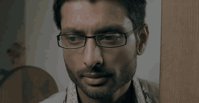 a close up of a man wearing glasses and earring