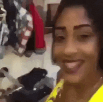 a woman is smiling and looking at the camera while standing in a room .