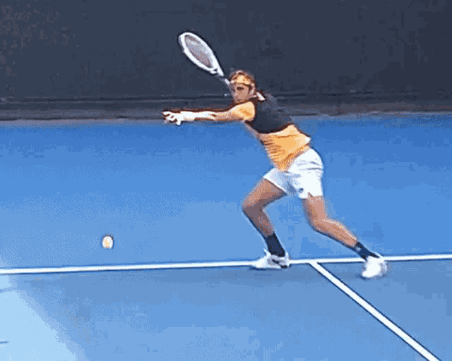 a man is swinging a tennis racquet on a blue court