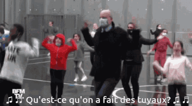 a group of people are dancing in front of a bfm tv sign