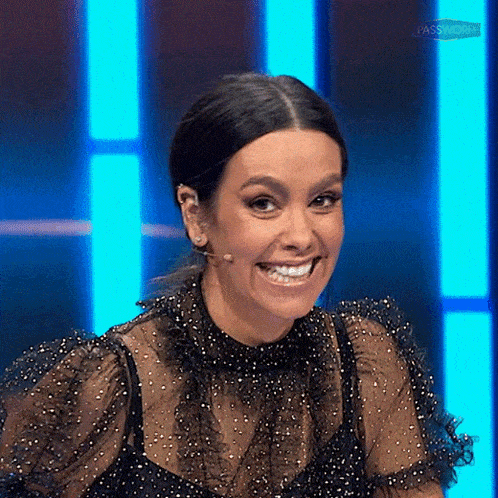 a woman in a black dress is smiling with a microphone in her ear .