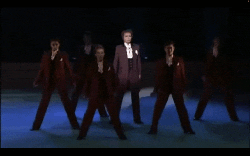 a group of men in tuxedos and bow ties are dancing on a stage