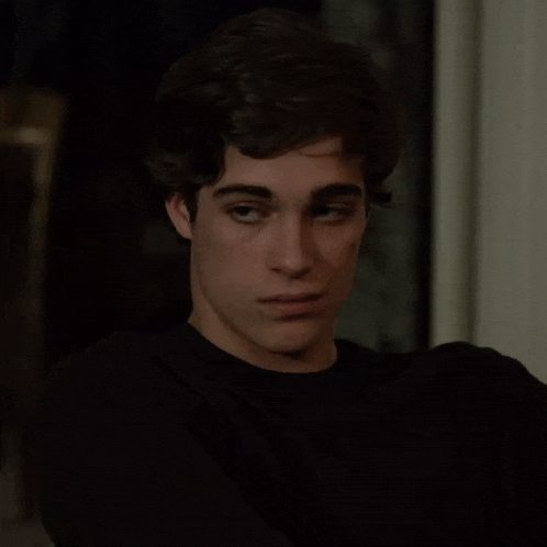 a young man wearing a black shirt looks at the camera