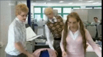 a woman in a pink sweater is standing next to a man and a woman