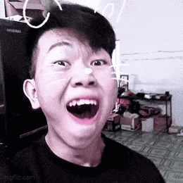 a young man is making a funny face with his mouth open in a room .