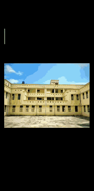 a large building with a lot of windows and a blue sky in the background