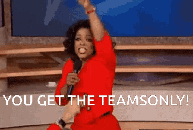 a woman in a red dress is holding a microphone and says you get the teamonly