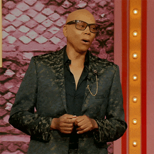 a bald man wearing glasses and a green jacket