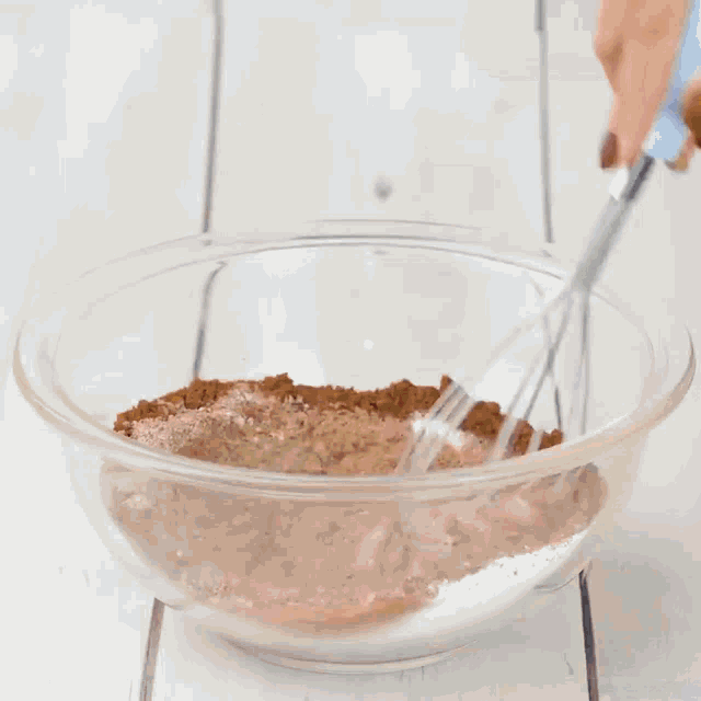 a person is cracking an egg into a bowl of chocolate