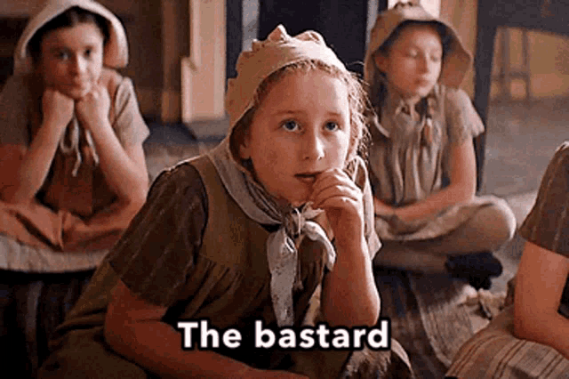 a group of young girls are sitting on the floor and one of them is holding her hand to her mouth and says the bastard .