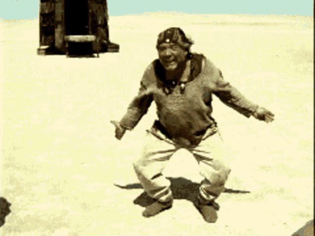 a man with his arms outstretched is standing in a desert