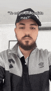 a man with a beard is wearing a hat and a jacket and taking a selfie .