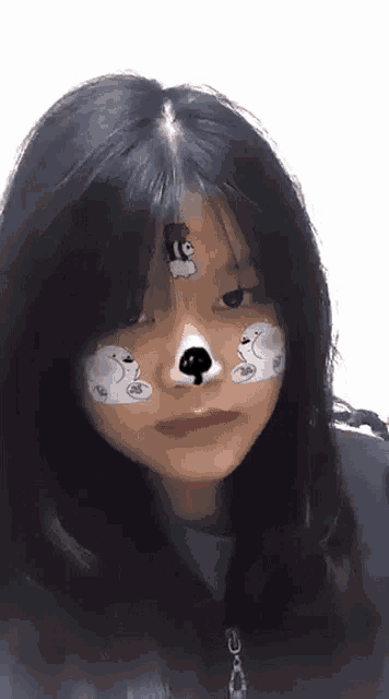 a girl with bears painted on her face is wearing a green shirt .