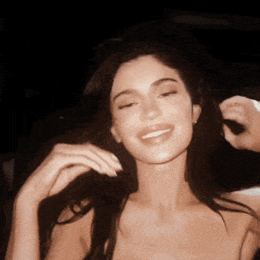 a close up of a woman 's face with her eyes closed smiling