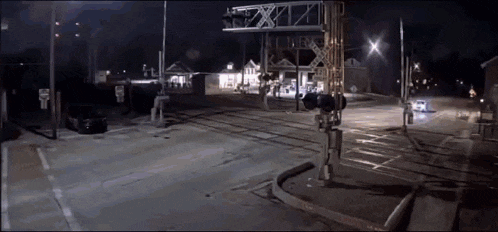 a train crossing at night with a sign that says ' flowers ' on it