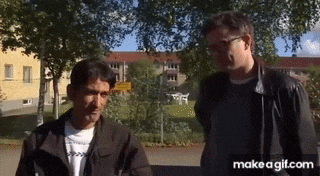 two men are standing next to each other in a park with a make a gif.com logo in the corner