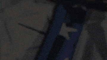a close up of a person wearing a white shirt with a purple and white strap
