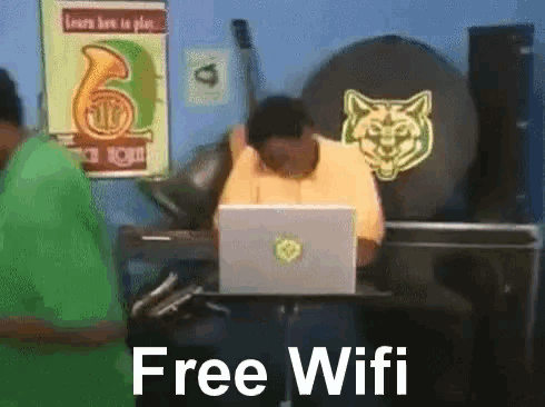 a man is sitting in front of a laptop with the words free wifi written below him