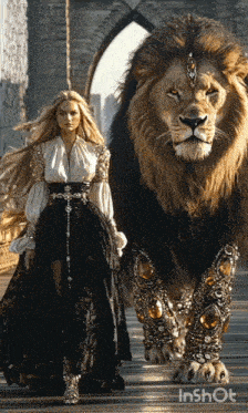 a woman in a long dress is walking next to a lion on a bridge