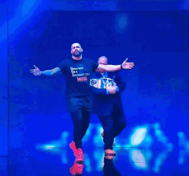 a man wearing a t-shirt that says greatness is the different life mode