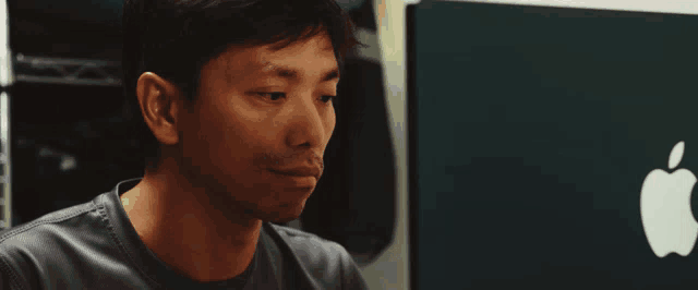 a man looking at an apple computer screen