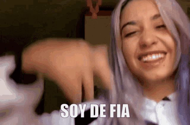 a woman with purple hair is smiling and says " soy de fia "