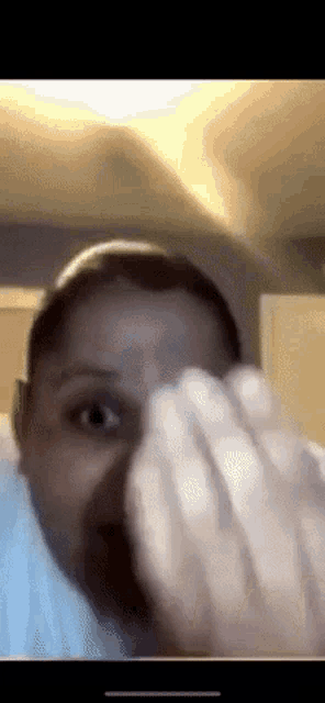 a close up of a person 's face with their hand on it