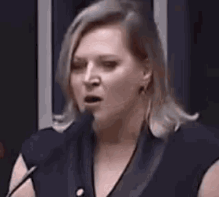 a woman is standing in front of a microphone .