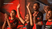 a group of people with their arms in the air wearing black and red jerseys with the letters jl on them