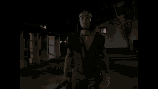 a man in a brown vest and hat is standing in a dark room