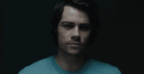 a close up of a man 's face with a blue shirt on