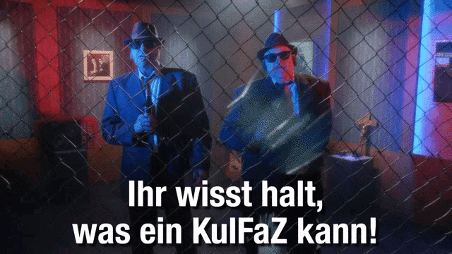 two men behind a chain link fence with the words ihr wisst halt was ein kulfaz kann on the bottom