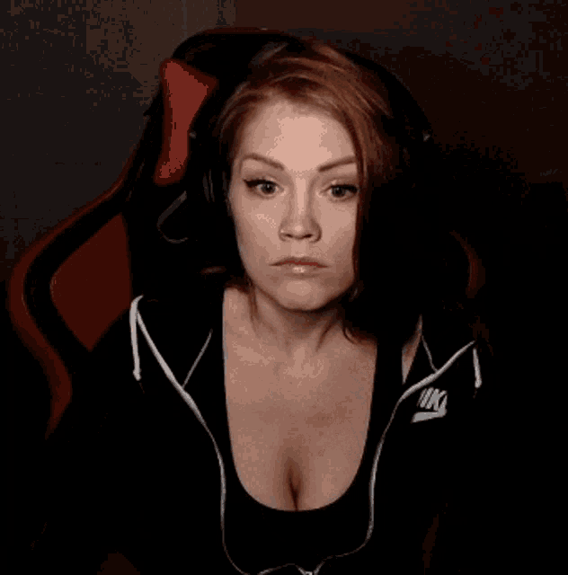a woman is wearing headphones and a black nike shirt