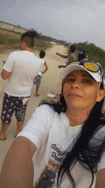 a woman wearing sunglasses and a white shirt that says amigos dança